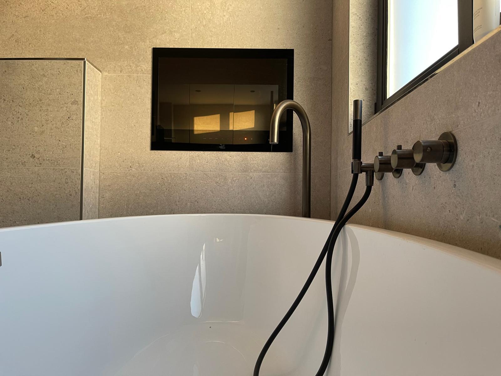Vrijstaand bad met goudkleurige kraan in luxe badkamer