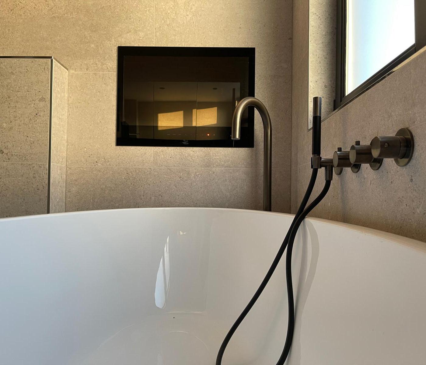 Vrijstaand bad met goudkleurige kraan in luxe badkamer